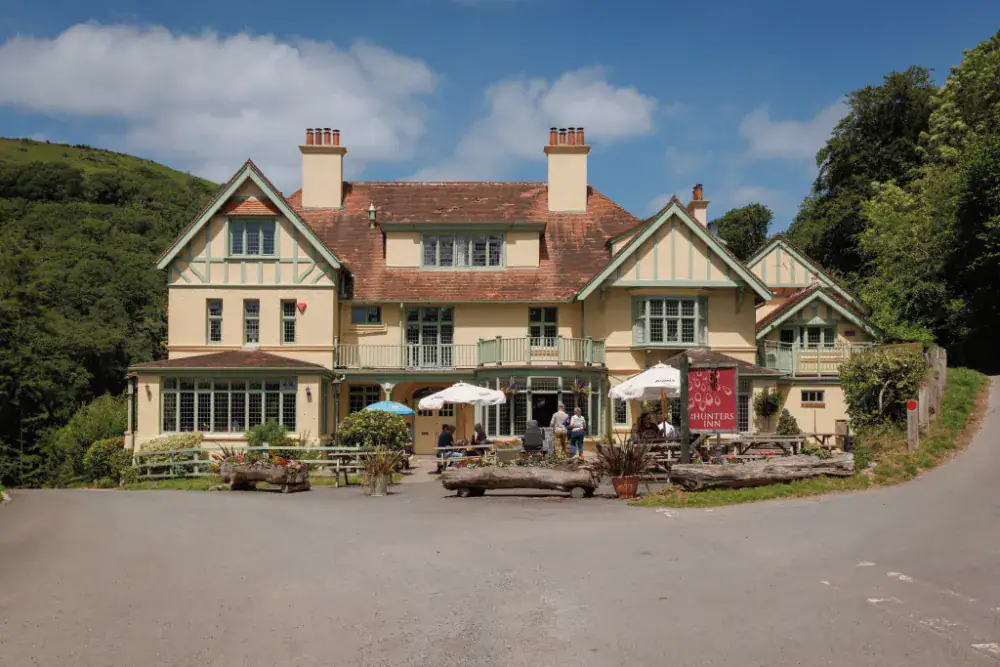 Charming historic inn with outdoor seating in a scenic village setting.