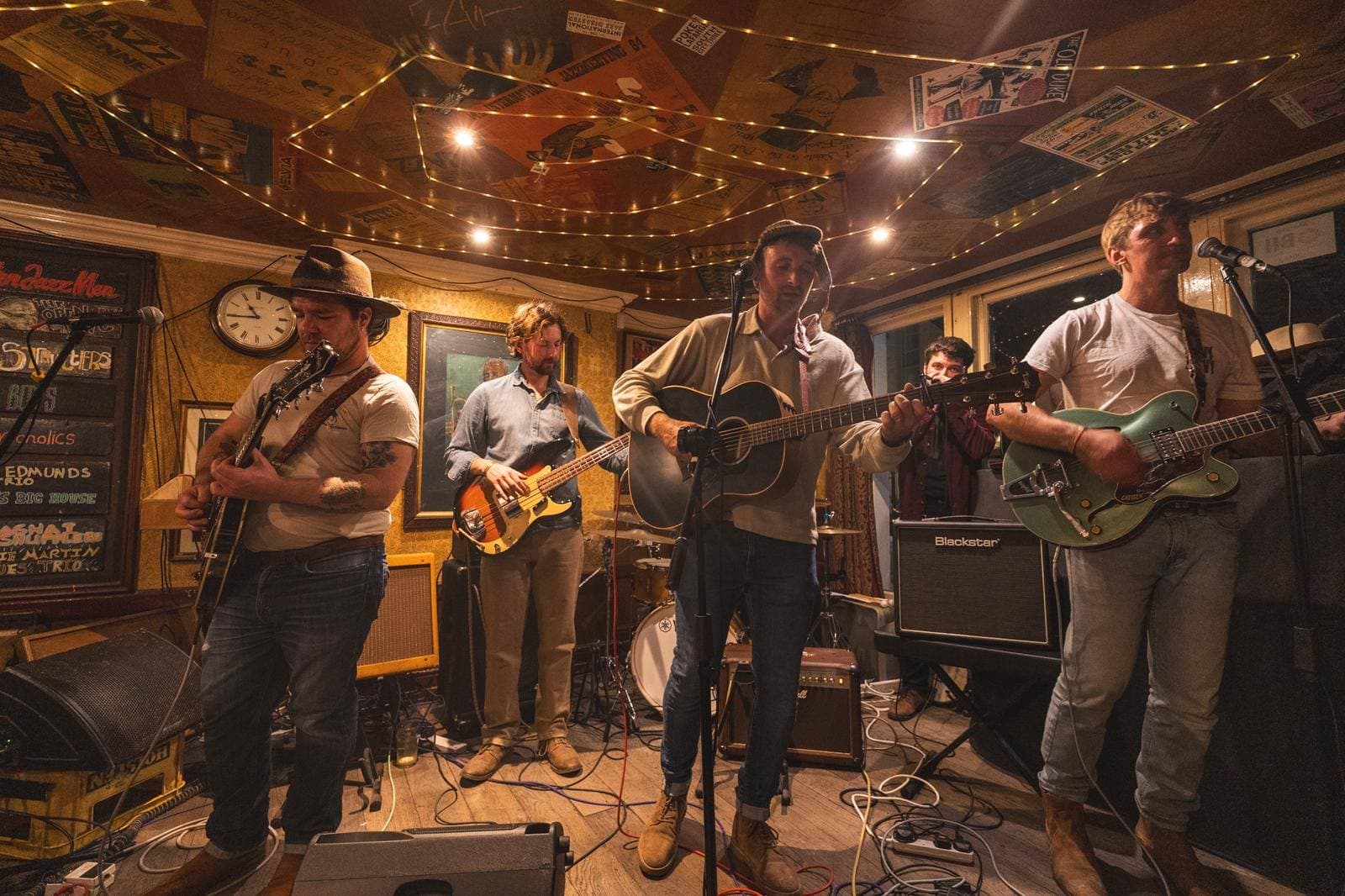 A band performing live music in a cosy pub with warm lighting and vintage decor.
