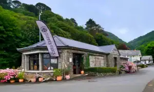 Coffee Shack Lynmouth with colourful outdoor plants and green hills behind on the seafront