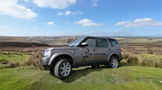 Red Stag Safari guide Andrew Turner with Land Rover on open Exmoor moorland