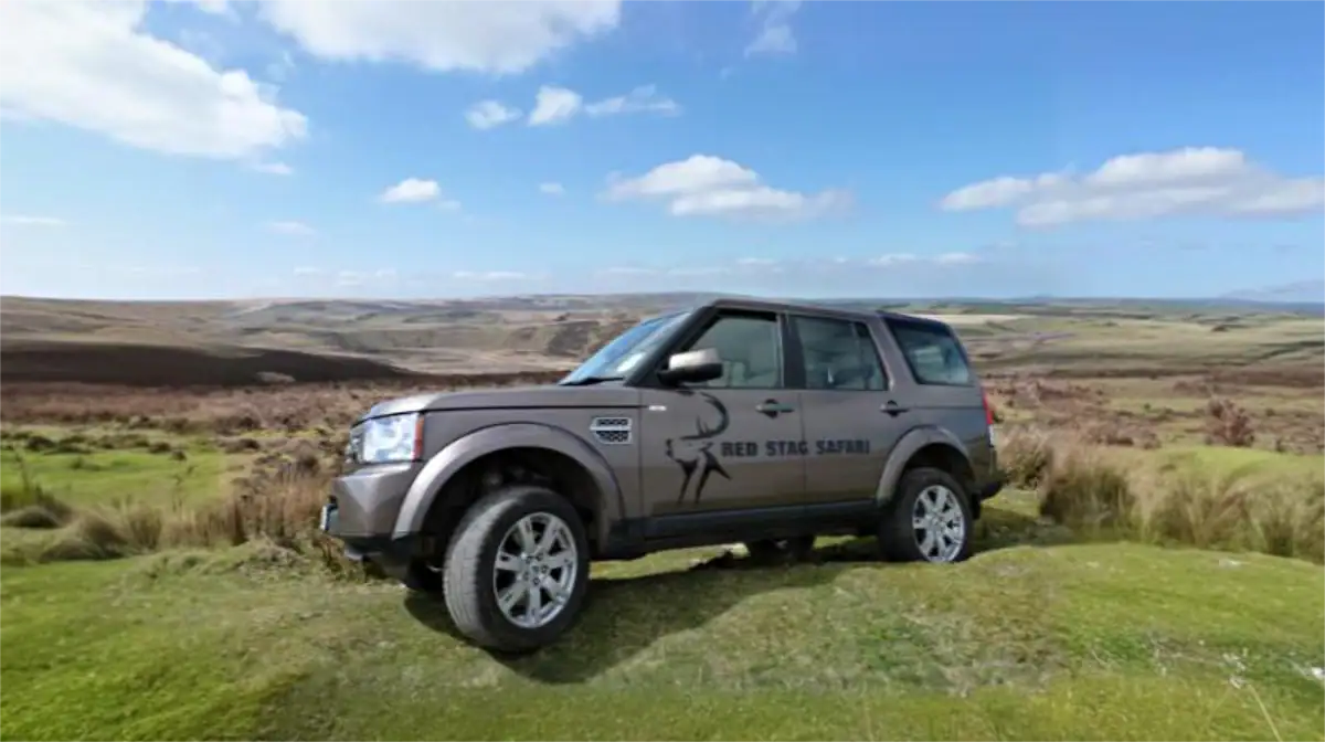 Red Stag Safari guide Andrew Turner with Land Rover on open Exmoor moorland