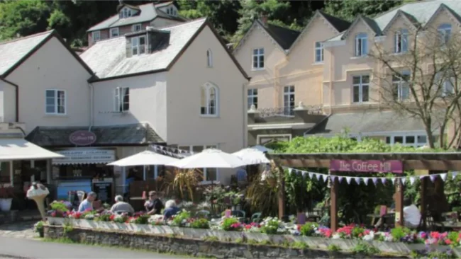 The Coffee Mill seating area beside Lynmouth Harbour with paved garden tables.