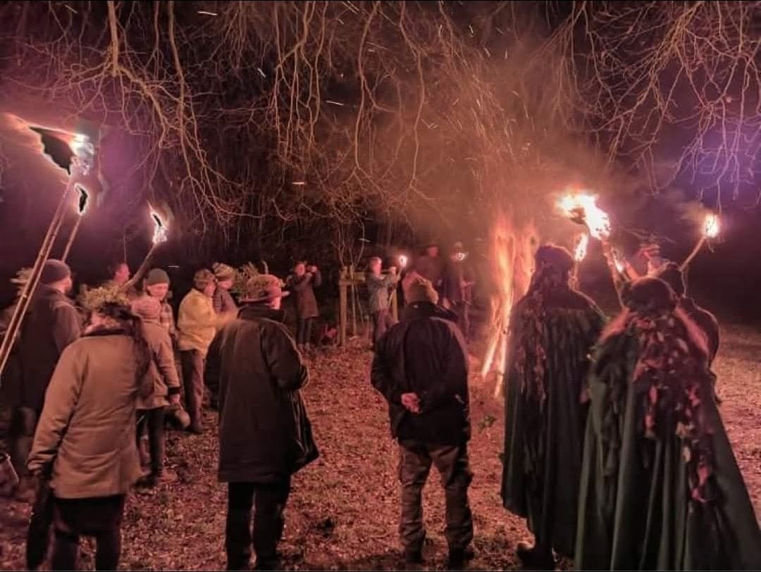 Visitors enjoying a torchlit gathering at Little Switzerland in Exmoor National Park, with torches illuminating the night.