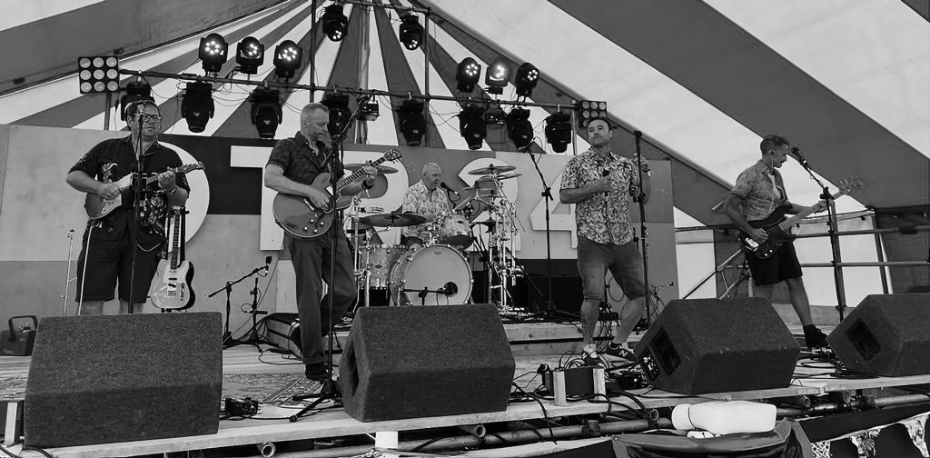 Band performing live music on stage at The Ancient Mariner pub, Lynmouth, during a vibrant event.