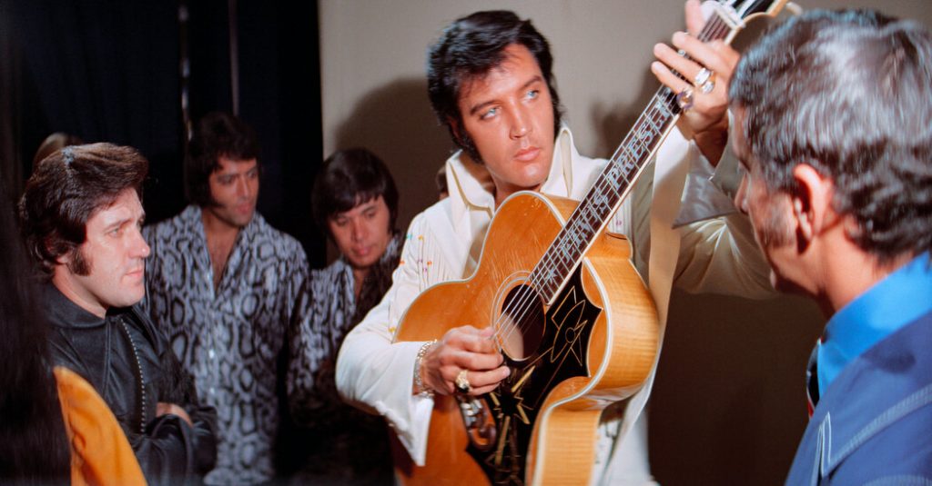 Elvis Presley performing with guitar at Lynton Cinema event.