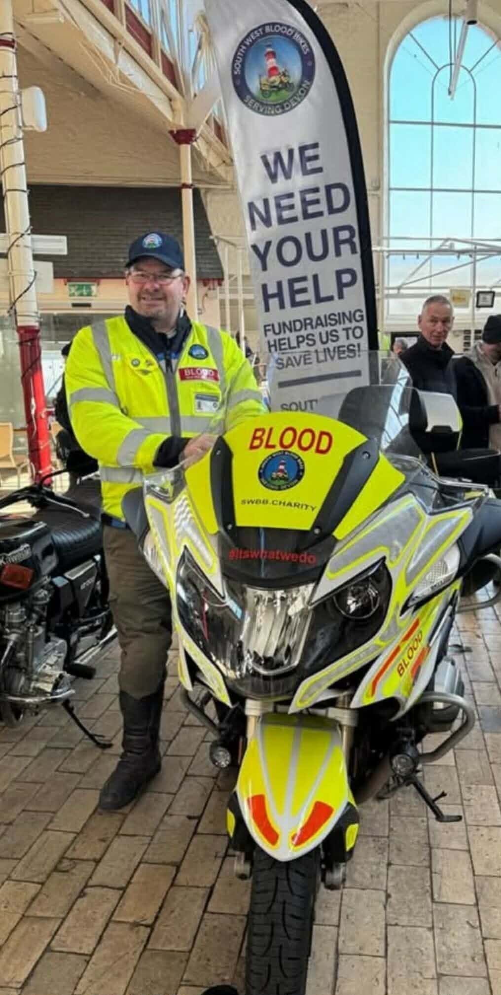 Emergency responder in high-visibility gear with motorcycle at Lynton & Lynmouth event.