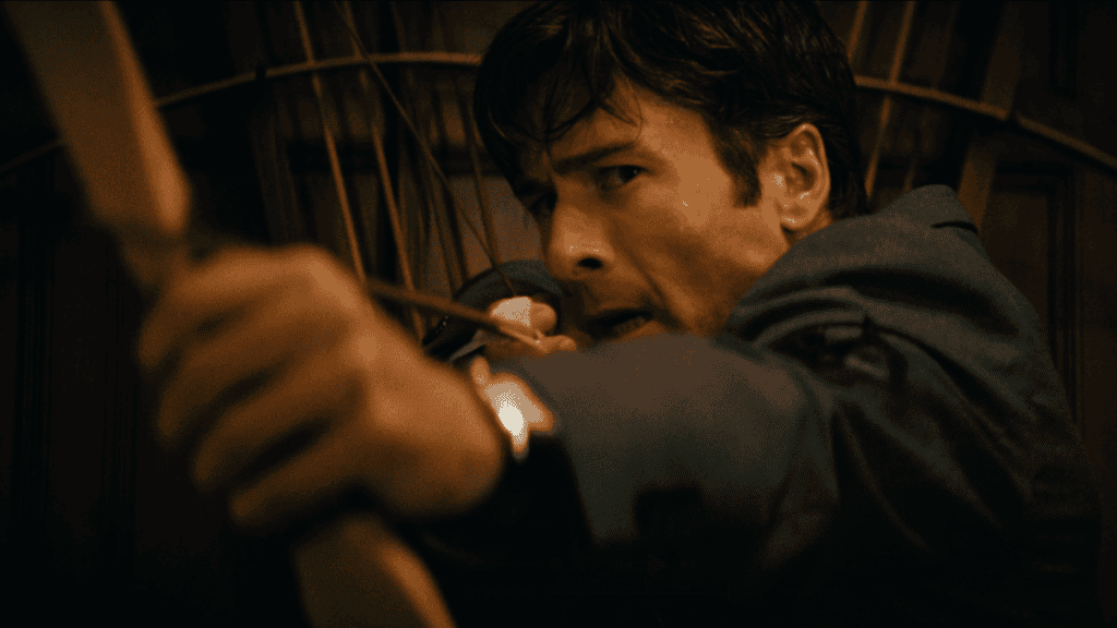 A tense moment featuring a man hiding in a dark, wooden setting, looking cautiously over his shoulde.