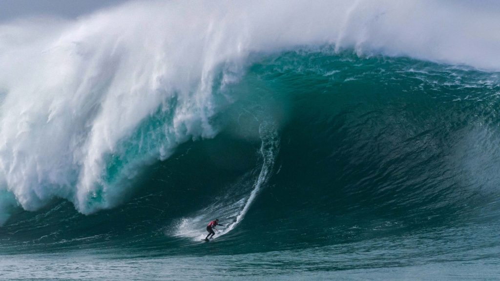A surfer riding a large wave in Lynton, North Devon.