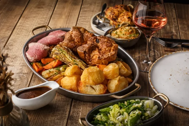 Delicious Sunday roast featuring roast beef, potatoes, vegetables, and gravy at Restaurant Kensingto.